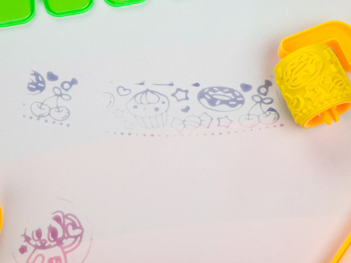 The yellow patterned roller printing a trail of cupcakes, hearts and stars across the mat